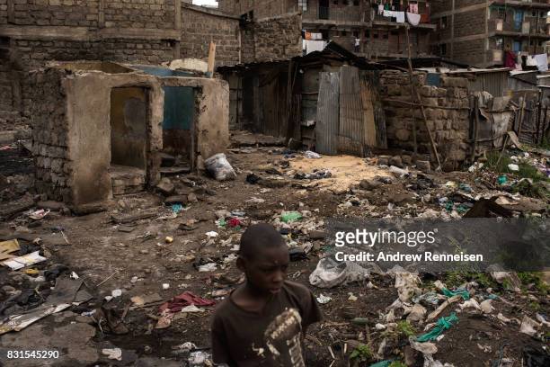Boy walks through homes that were burned in unrest two days prior in the Mathare North neighborhood on August 14, 2017 in Nairobi, Kenya. Nairobi...