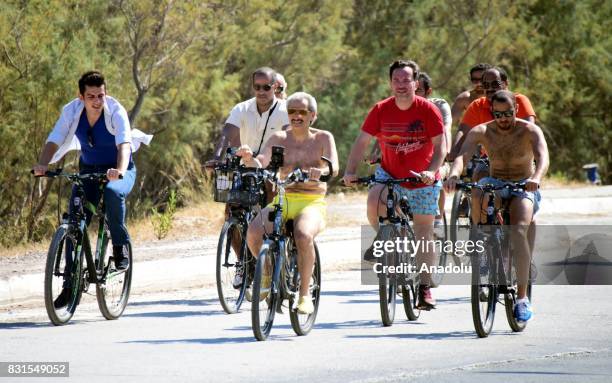 Saudi Prince Al-Waleed Bin Talal bin Abdulaziz al Saud rides bicycle along with his bodyguards and fellows in the Aegean sea resort of Bodrum of...