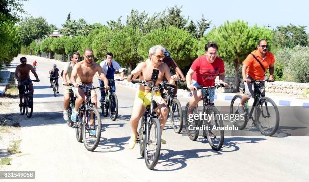 Saudi Prince Al-Waleed Bin Talal bin Abdulaziz al Saud rides bicycle along with his bodyguards and fellows in the Aegean sea resort of Bodrum of...