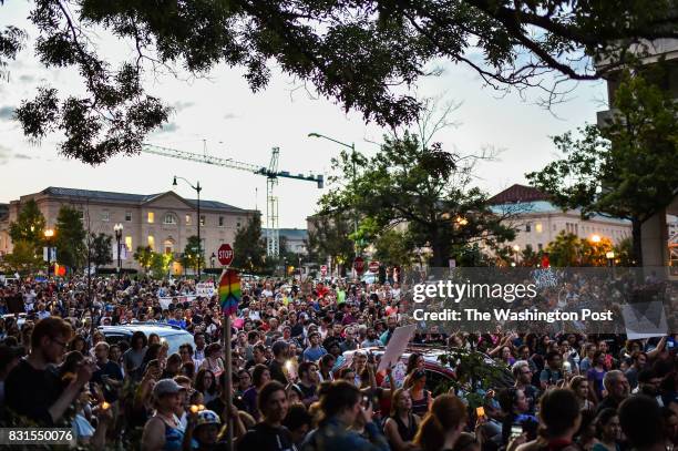 People hold a vigil in front of the statue of Albert Pike, a Confederate general, at Judiciary Square on Sunday, August 13 in Washington, D.C., a day...