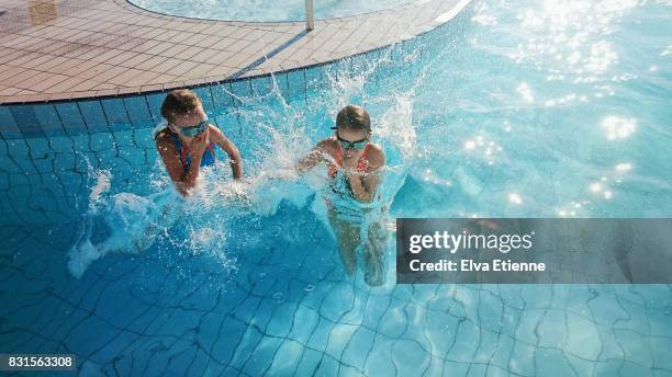 two children jumping into a swimming pool - swimming pool jump stock pictures, royalty-free photos & images