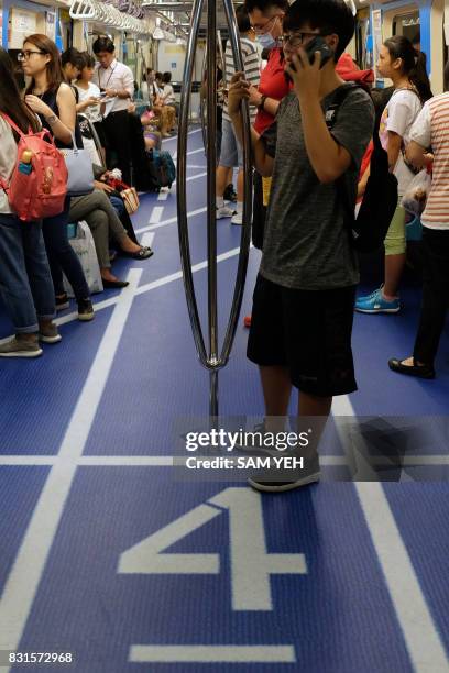 This picture taken on August 7, 2017 shows a carriage of the Mass Rapid Transport train decorated with an image of a running track to promote the...