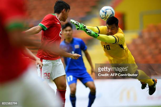 Thailand's Nont Muangngam blocks a shot on goal by Indonesia's Septian David Maulana during their men's football Group B round match of the 29th...