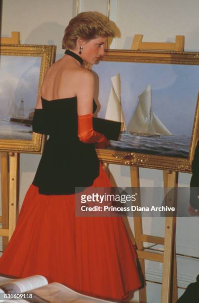 Diana, Princess of Wales wearing a Murray Arbeid flamenco dress with one red glove and one back glove, attends the America's Cup Ball at the...