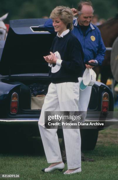 Diana, Princess of Wales wearing a navy blue sweater and straight leg white trousers at a Guards Polo Club match at Smiths Lawn, Windsor, May 1986.