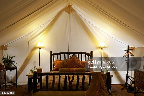 tent interior with bed and lamps. - luxury tent stock pictures, royalty-free photos & images