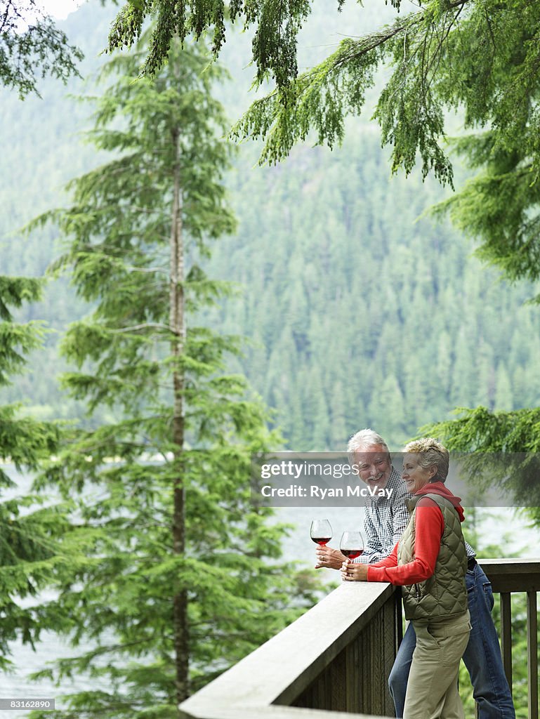 Mature couple on deck drinking wine