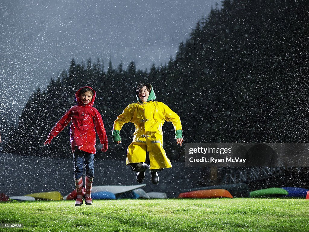 Bruder und Schwester Spielen im Regen.