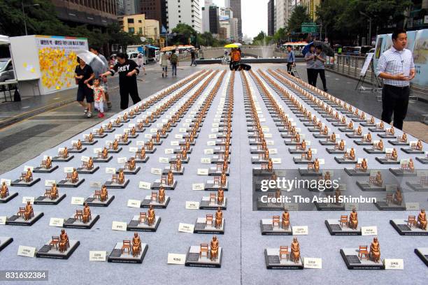 Civic groups display 500 miniature seated statues of a girl representing "comfort women" in Cheonggye Stream Square on August 14, 2017 in Seoul,...