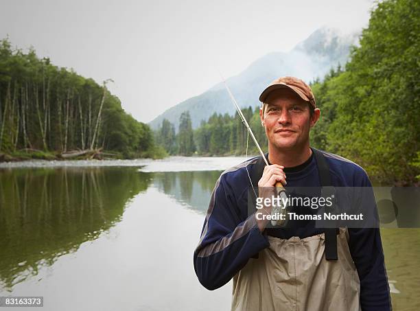 porträt von fly fisherman, steht im river - fliegenfischen stock-fotos und bilder
