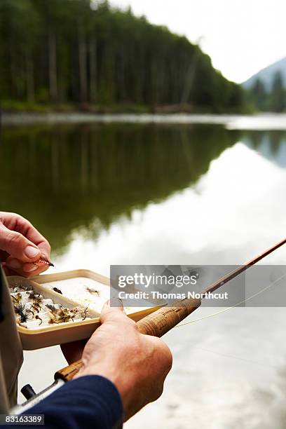 man holding fly fishing lures - fishing tackle box stockfoto's en -beelden