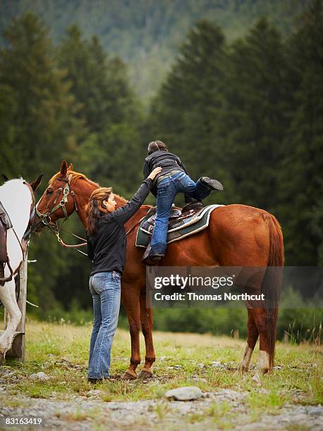 mutter hilft tochter auf pferd - enable horse stock-fotos und bilder