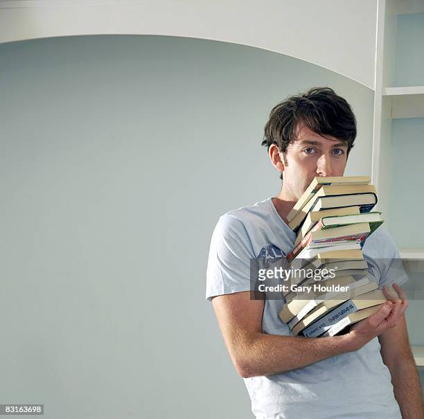 uomo bilanciamento grande pila di libri con una mano - gary balance foto e immagini stock