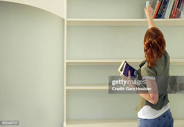 donna eliminandoli dallo scaffale - bookshelf foto e immagini stock