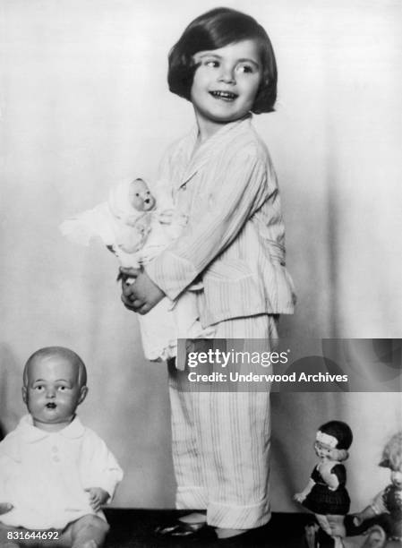 Little Baroness Anna Soragno holds a doll presented to her by the Crown Princess of Italy, Rome, Italy, June 1930. At left is a doll from the Crown...