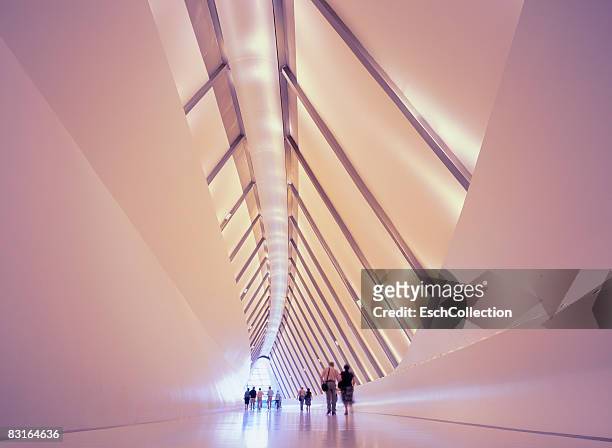 people crossing zaha hadid's pedestrian bridge - medium group of people stock pictures, royalty-free photos & images
