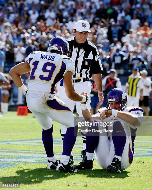 Referee Peter Morelli looks on as wide receiver Bobby Wade helps up quarterback Gus Frerotte of the Minnesota Vikings after Frerotte was sacked and...