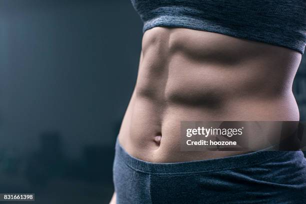 woman showing abdominal muscles - woman perfect body imagens e fotografias de stock