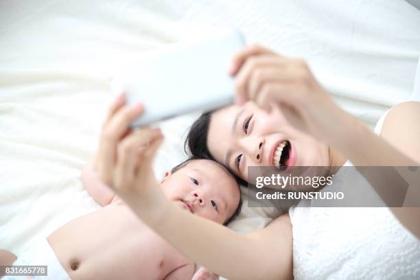 mother and baby taking a selfie - woman on plain background stock pictures, royalty-free photos & images