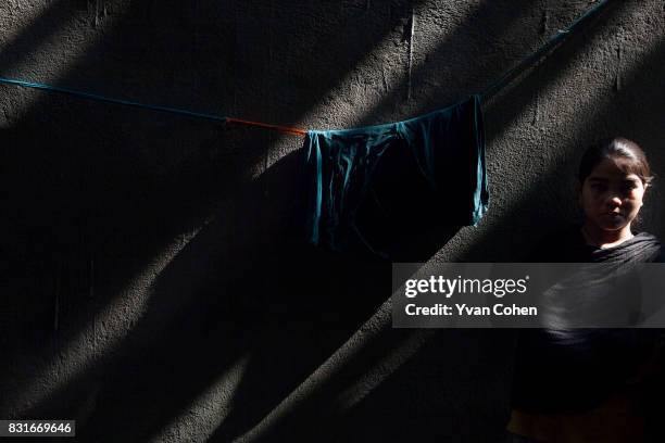 Girl in the shadows in a side street in the Fakir Bagan slum area of Kolkata. Founded in 2004, Calcutta Kids is a not-for-profit public health...