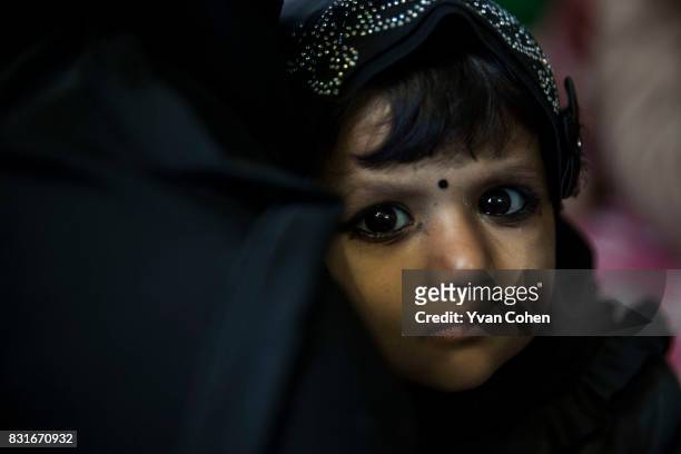 Muslim woman and her child wait at a clinic in the Fakir Bagan slum area of Kolkata. The clinic is run by the charity Calcutta Kids. Founded in 2004,...
