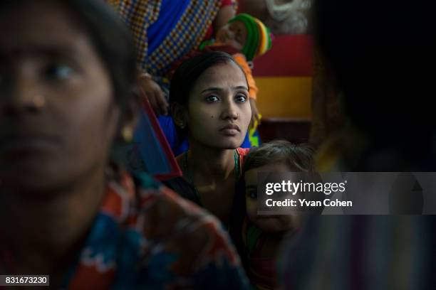 Young mother looks at the camera as she waits at a clinic in the Fakir Bagan slum area of Kolkata run by the charity Calcutta Kids. Founded in 2004,...