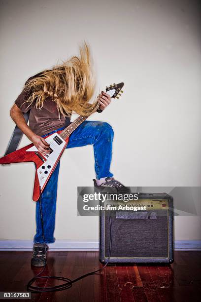 man thrashes head while playing guitar. - headbanging stock pictures, royalty-free photos & images