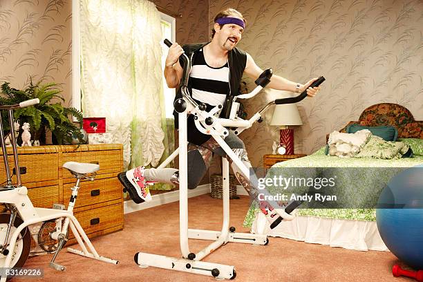 man execising on vintage equipment in home gym - funny stock-fotos und bilder