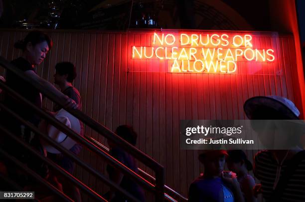 Customers walk by a neon sign at Hard Rock Cafe on August 15, 2017 in Tamuning, Guam. The American territory of Guam remains on high alert as a...