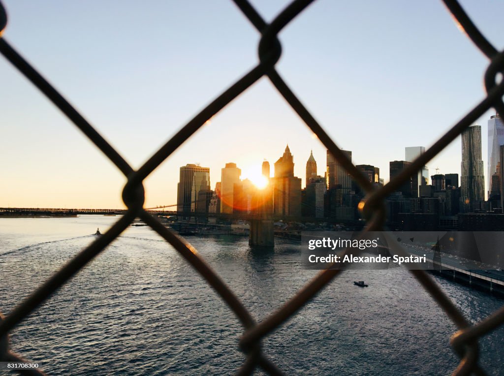 Manhattan skyline seen through a chainlink fence