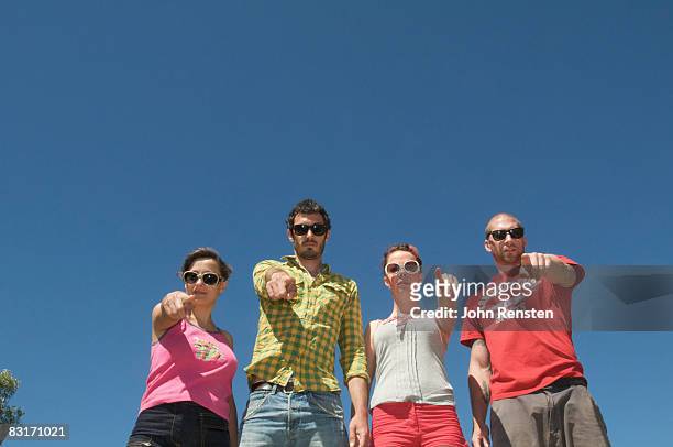 four people pointing in same direction - same person different outfits stock-fotos und bilder