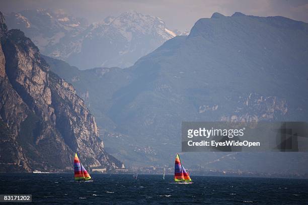 Two catamaran sailing boats and a view from the promenade in Malcesine to the northern part of Lake Garda and the city of Riva del Garda on September...