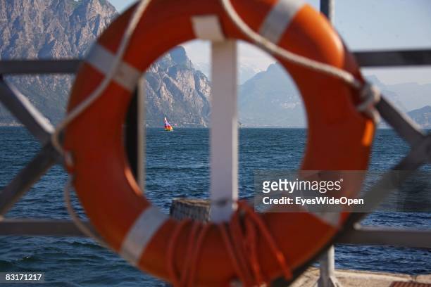 Catamaran sailing boat and a view from the promenade in Malcesine to the northern part of Lake Garda and the city of Riva del Garda on September 25,...
