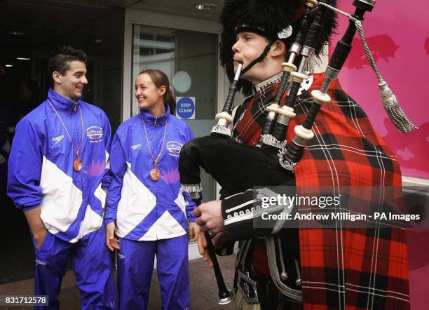 Piper walks past badminton bronze medalist Susan Hughes and gymnastic bronze medalist Adam Cox after they arrived at Glasgow Airport, Wednesday March...