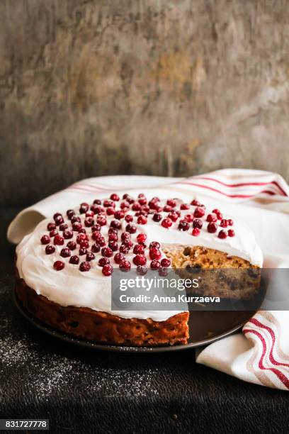 homemade christmas cake with dried fruits decorated with sweet vanilla meringue, fresh cranberry and icing sugar on a plate, selective focus - fruta seca fotografías e imágenes de stock