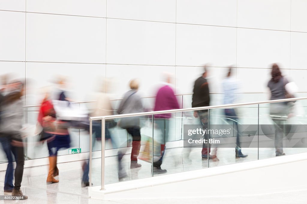 Menschen gehen durch die weiße Flur