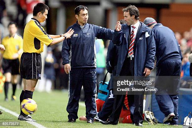 Aurelio Vidmar of United is pushed back by the referees during the AFC Champions League semi-final first leg match between Adelaide United and...
