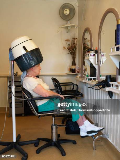 Senior woman sitting under the hair dryer at a Salon in Blackpool, England, 29th August 2007. .