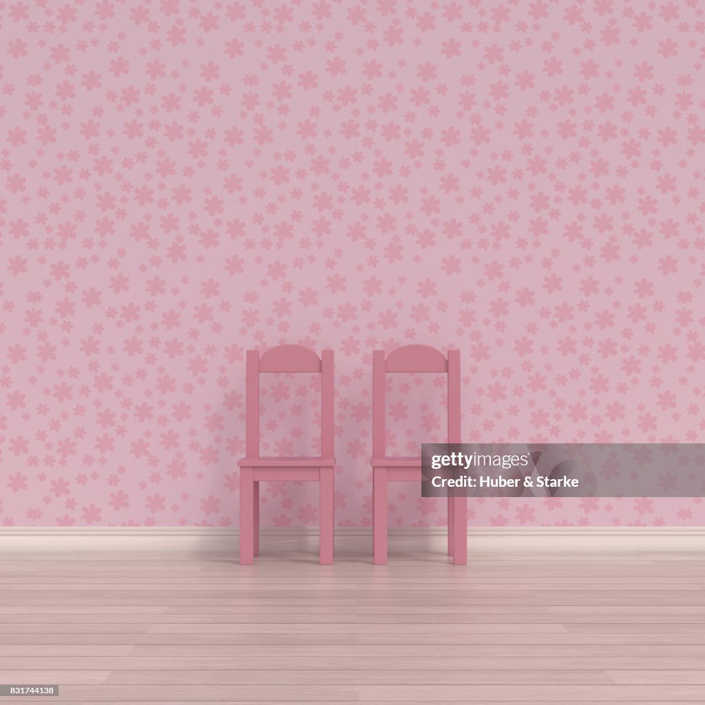 Two child's chairs in front of floral patterned wall paper