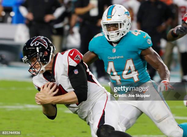 Matt Simms of the Atlanta Falcons goes to the ground as Deon Lacey of the Miami Dolphins pursues during a preseason game at Hard Rock Stadium on...
