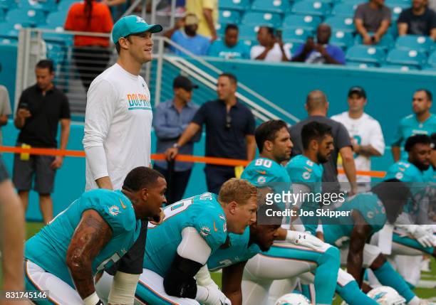 Ryan Tannehill of the Miami Dolphins, above, looks over teammates before play against the Atlanta Falcons during a preseason game at Hard Rock...