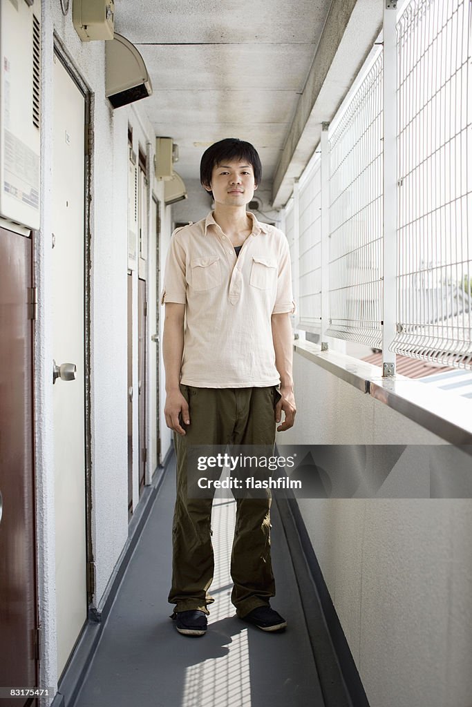 Portrait of Japanese man in front of his apartment