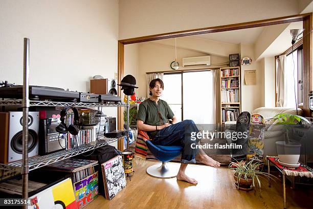 japanaese man in his aparment - asian man sitting casual imagens e fotografias de stock