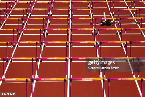 Deborah John of Trinidad and Tobago falls as she competes in the Women's 100 metres hurdles heats during day eight of the 16th IAAF World Athletics...