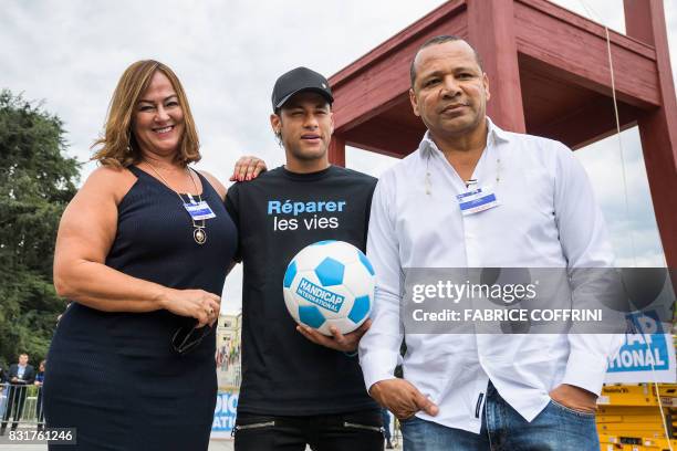 Brazilian superstar and world's most expensive footballer Neymar poses with his father Neymar Santos and his mother Nadine Santos next to a...