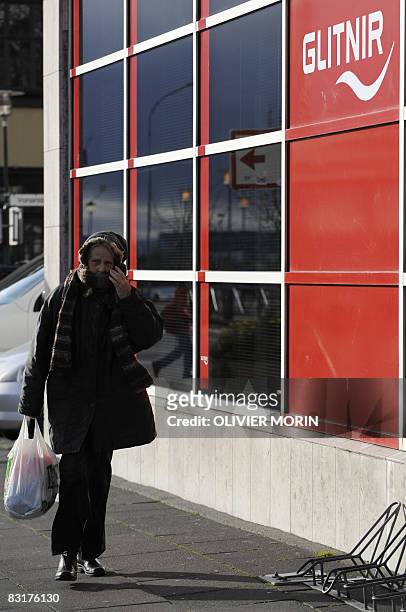 Woman walks past a branch of the Icelandic bank Glitnir in Reykjavik on October 8, 2088. The Icelandic state has officially taken control of the...