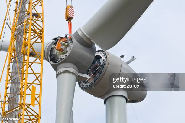 montage der rotorblätter an einer windkraftanlage - building activity stock-fotos und bilder