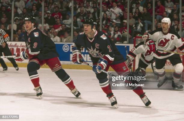 Canadian ice hockey players Adam Graves and Mark Messier of the New York Rangers skate away from Scott Stevens of the New Jersey Devils during game...