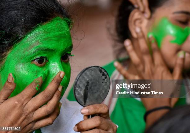 College students paint their face as they get ready for a cultural event in the run up to the Dahi Handi celebrations of 'Janmashtami', which marks...