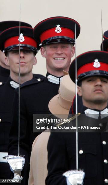 Prince Harry smiles broadly as his grandmother Queen Elizabeth II reviews him and other officers during The Sovereign's Parade at the Royal Military...